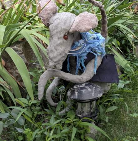 Sculpted rat with fur-trimmed ears and a blue scarf